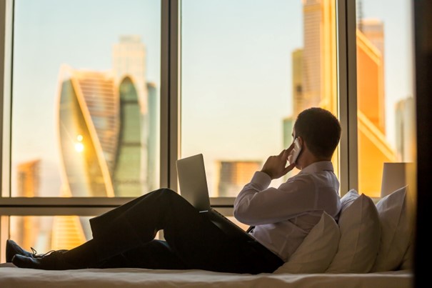 Osoba w hotelu siedząca na parapecie z widokiem na miasto